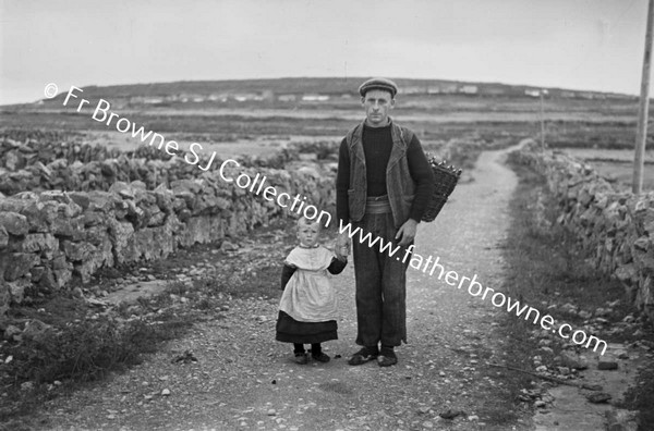 MAN WITH CHILD ON ROAD. FATHER AND SON ON INISHEER